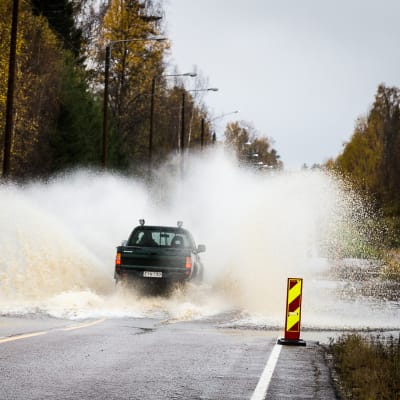 Bil kör på översvämmad väg