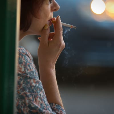 Nainen polttaa tupakkaa.