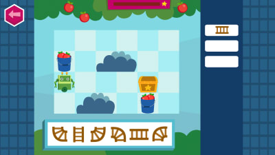 Koodaus-peli, jossa on ruudukko ja eripäin olevia radanpalasia. Ruudukossa on vihreä robotti, kaksi omenaämpäriä, aarrearkku ja kaksi sinistä puskaa.