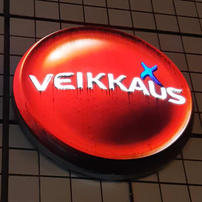 En upplyst Veikkaus-logo på en husvägg