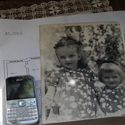 En gammal mobiltelefon och en gammal bild på systrarna.
