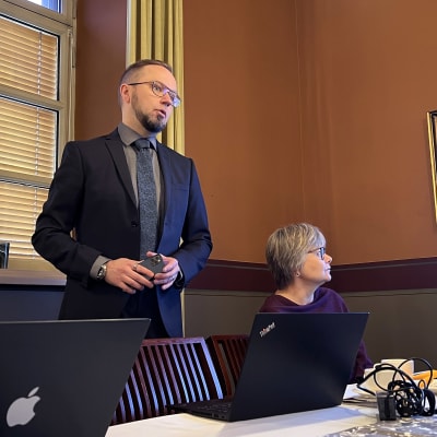 Tarja Majuri istumassa vasemmalla, Olli-Poika Parviainen  seisomassa ja Päivi Raukko istumassa pöydän ääressä Hämeenlinnan raatihuoneen kokoushuoneessa esittelemässä palveluverkkoselvitystä.