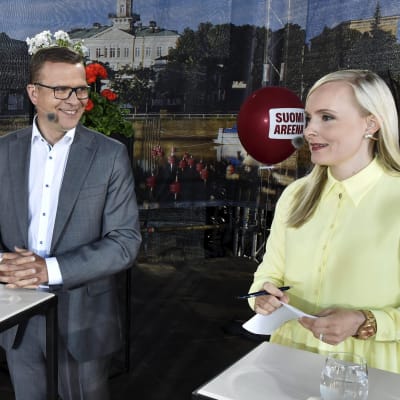 Samlingspartiets ordförande Petteri Orpo och De grönas Maria Ohisalo står bredvid varandra inför debatt.
