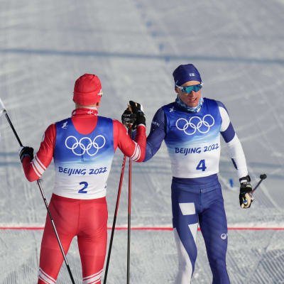 Iivo Niskanen och Alexander Bolsjunov slår händerna ihop vid målgång efter ett lyckat lopp i herrarnas skiathlon.