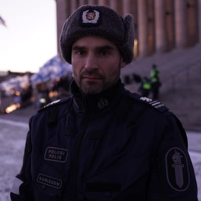 Patrik Karlsson i polisuniform utanför riksdagshuset.