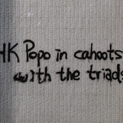 Bild på graffiti. Hongkongs polis har fått öknamnet HK Popo. På graffitin beskylls den för att vara i maskopi med maffian.