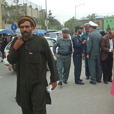 Kabulbor och poliser vid stånden på en gata i centrala Kabul.