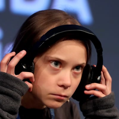 Yrmeä Greta Thunberg kuulokkeet korvilla.