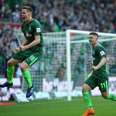 Fotbollsspelaren Niklas Moisander hoppar upp i luften och firar ett mål.