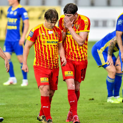 Jacek Kielb håller för munnen och talar med Petteri Forsell.