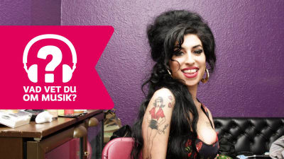 Amy Winehouse ler med öppen mun.