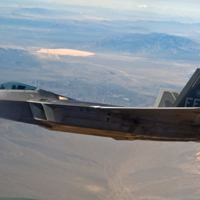 Ett F-22 Raptor-jaktplan med Area 51 i bakgrunden.