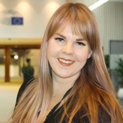 Alviina Alametsä tittar rakt in i kameran och ler. I bakgrunden syns ett kontor.