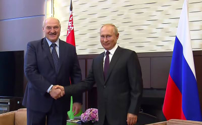 Två män ler mot kameran medan de skakar hand. Männen är Rysslands president Vladimir Putin och Belarus president Aleksandr Lukasjenko.