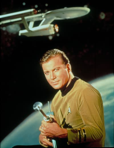 Kapteeni Kirk poseeraa sädepistoolin kanssa taustanaan planeetta