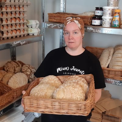 Leipomoyrittäjä Mimmi Tick pitää sylissään koria, jossa on hapanjureen leivottuja leipiä.