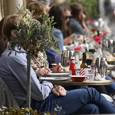 Ihmisiä nauttimassa lämpimästä säästä The Cock -ravintolan terassilla Helsingissä 3. kesäkuuta 2021.
