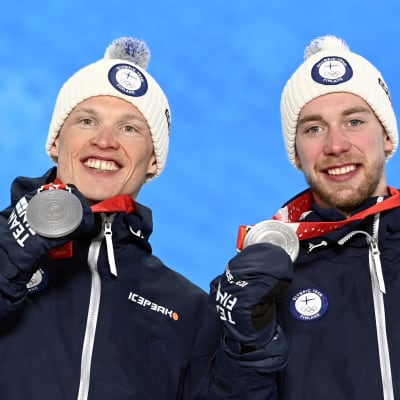 Iivo Niskanen och Joni Mäki visar upp sina medaljer.