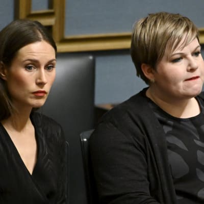 Sanna Marin och Annika Saarikko med allvarliga miner i riksdagen.