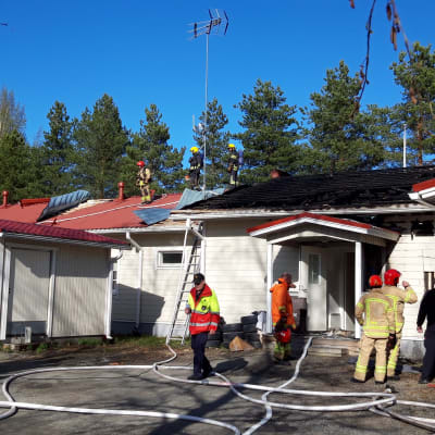 Palomiehet sammuttamassa Kauhajoen Aronkylässä rivitalon paloa 19.5.2022