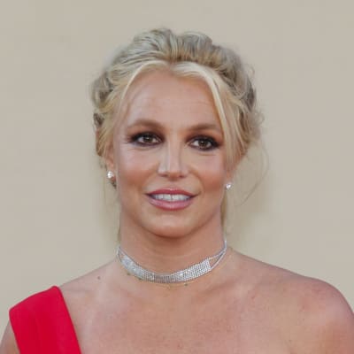 Britney Spears tittar åt sidan och ler på röda mattan.