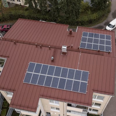 Aurinkopaneelit kerrostalon katolla.
