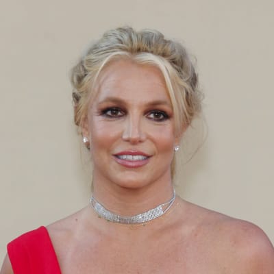 Britney Spears tittar åt sidan och ler på röda mattan.