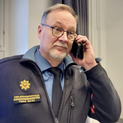 Olympimitalisti Joni Mäen isä, Tero Mäki puhuu puhelimeen yllään pelastusjohtajan univormu.