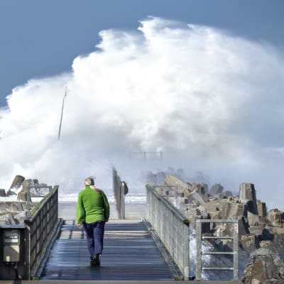 Stormen Knud slår upp stora vågor över en pir utanför Hanstholm, Danmark.