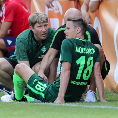 Niklas Moisander sitter på gräset och får behandling