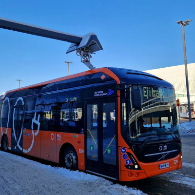 Helsingin Bussiliikenne oy:n sähköllä toimiva nivelbussi latautumassa Helsinki-Vantaan lentoaseman latauspisteellä.  