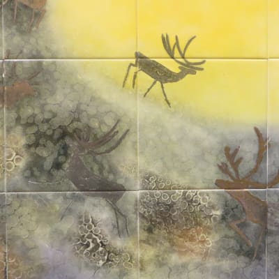 Kuvassa osa Annikki Riekon posliinimaalauksessa, jossa näkyy poroja ja aurinko