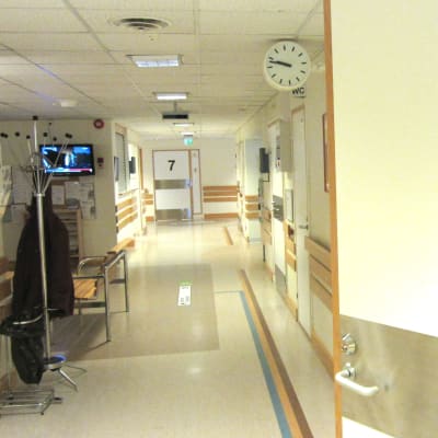 En korridor på ett sjukhus med många dörrar.