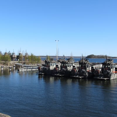 Militärbåtar förtöjda vid en brygga. Sommar, solsken.