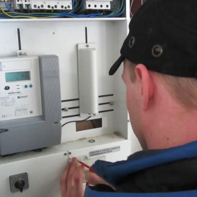 En man installerar en elmätare.