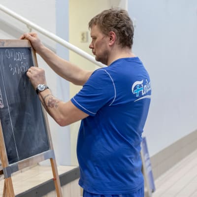 Uintivalmentaja Marko Malvela piirtää harjoitusohjelmaa liitutaululle.
