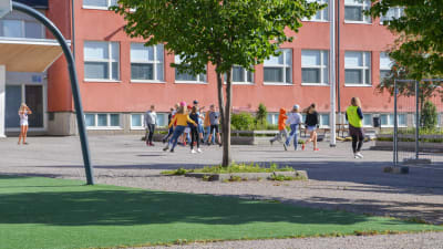 Skolelever springer ute på skolgården