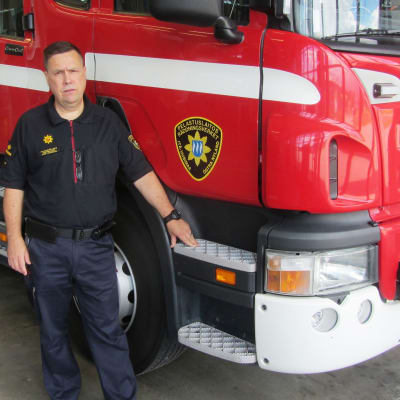 Räddningschef Peter Johansson vid en släckningsbil av samma typ som den som ska bytas ut