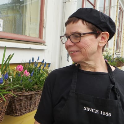 Monica Hänninen beundrar blommorna utanför lunchrestaurangen Hanna-Maria i Borgå