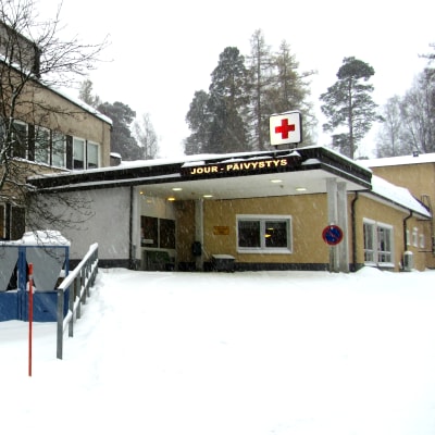 Ett sjukhus med en jourmottagning i ett snöigt vinterlandskap.