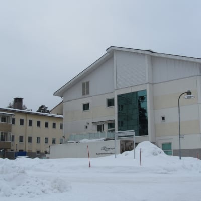 Vita våningshus vid Raseborgs sjukhus i ett vinterlandskap.