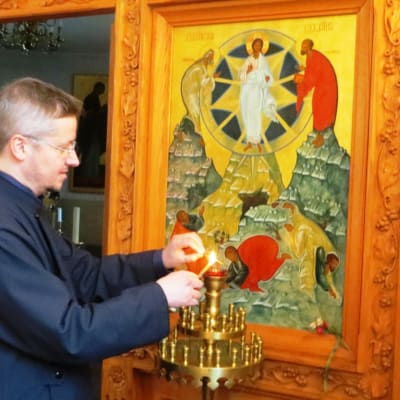 Pastor Mikael Sundkvist tänder ljus i Borgå ortodoxa kyrka
