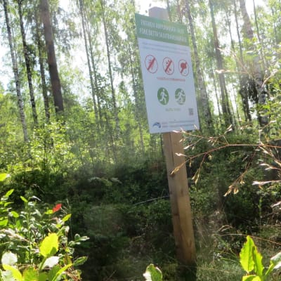 Varningsskylt för plockning av bär och svampar längs motionsbanan i Nickby