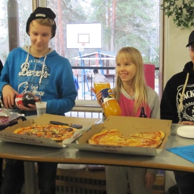 neljä kahdeksasluokkalaista myyvät leivonnaisia luokkarahaston hyväksi koulun aulassa