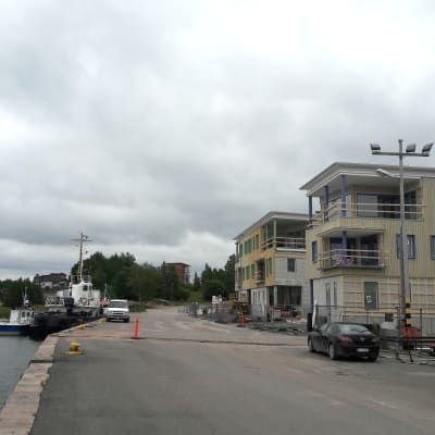 En kajkant där ett större fartyg står ankrat. Till vänster syns nybyggda bostadshus.