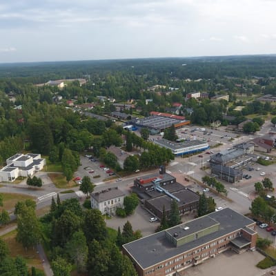 Ilmakuva Iitin kuntakeskuksesta Kausalasta. Erikokoisia taloja, teitä ja ouita. Kesäinen kuva.