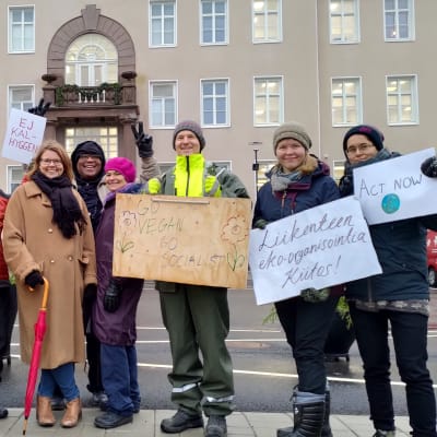 Demonstranter med plakat står utanför stadshuset i Raseborg.