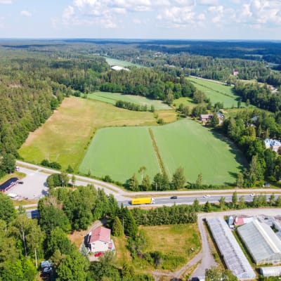 Drönarbild över obebyggd åkermark i Västerby, mellan Trollbölevägen och Mikaelskolan i Ekenäs. Här finns preliminära planer på en ny vägsträckning av stamväg 52 och en planskild korsning.