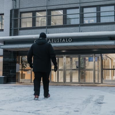 Mies kävelee kohti Keski-Suomen käräjäoikeuden ovia.