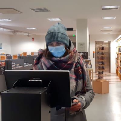 Kemiläinen Sanna Sotaniemi asioi Kemin kaupunginkirjaston lainausautomaatilla. 